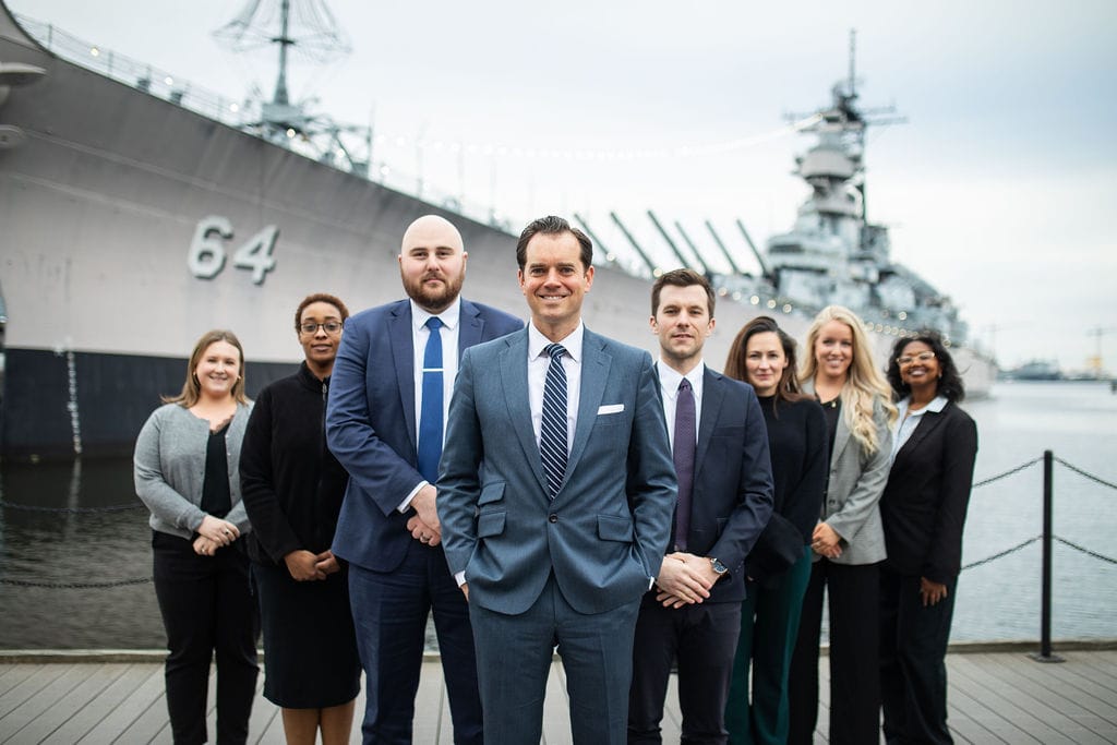 The McCormick Law & Consulting team on the Norfolk waterfront near the USS Wisconsin
